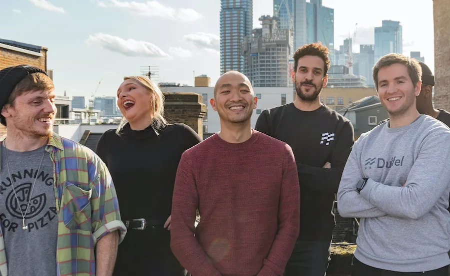 Five people on a rooftop smiling and posing for the camera.