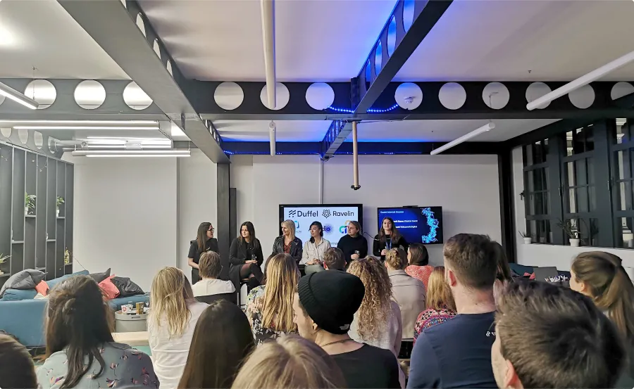 Six women on panel answering question to a room full of people.